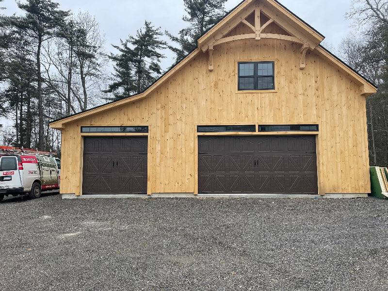 16' x 8', Amarr Classica – DSI Custom Engineered Vertical lift track below the window and 9' x 8',  follow the roof pitch install. The team installed engineered the spring line below the window to avoid interfering with the window on a customer supplied material install for The Barn Yard.